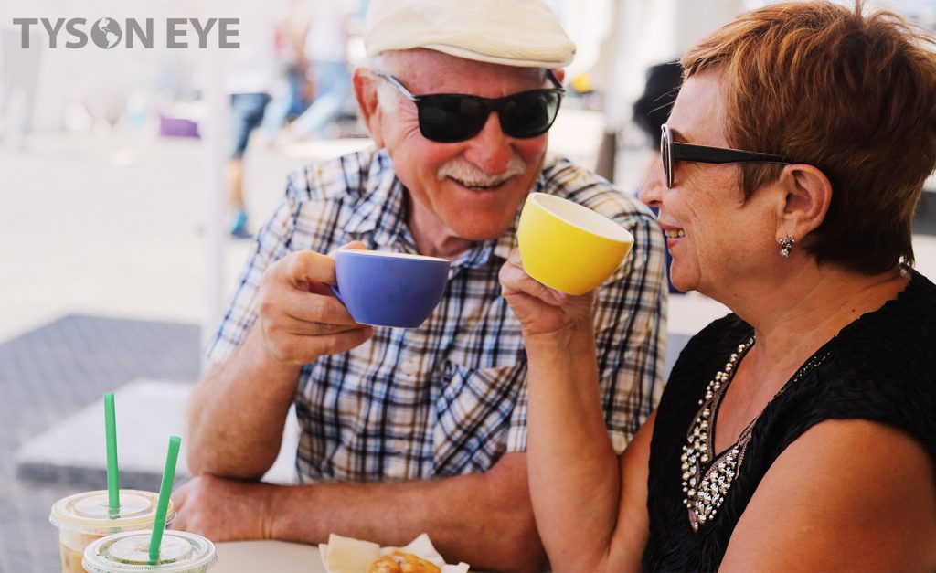 Couple drinking coffee together and protecting their eyes with UV protection