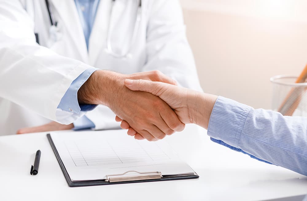 A doctor shaking hands with his patient