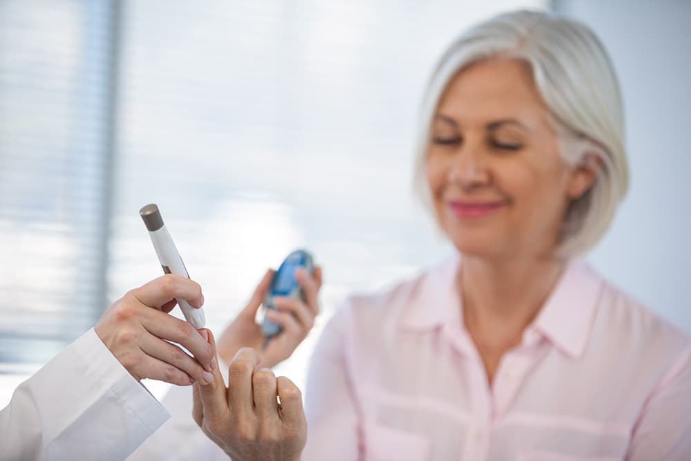 A senior woman testing her blood sugar levels