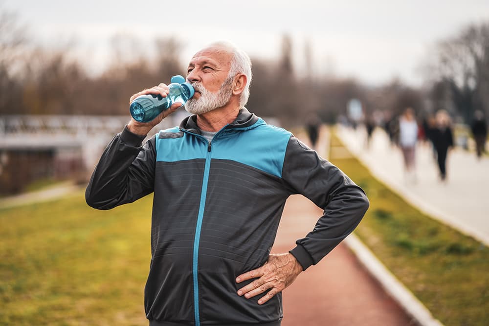 Active senior man drinking from a sports water bottle