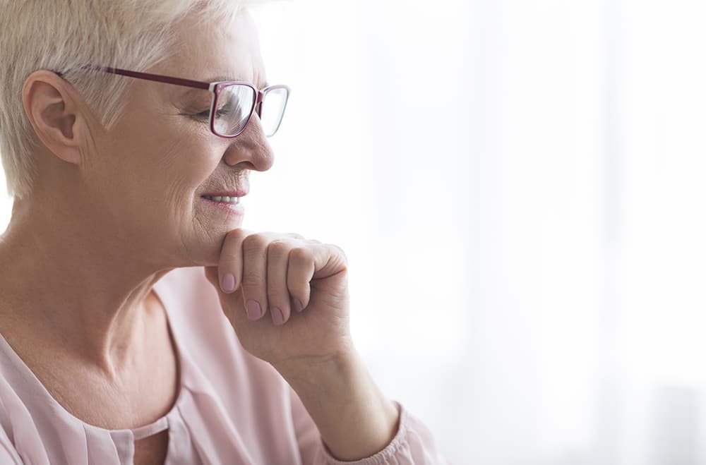 Senior woman with glasses thinking