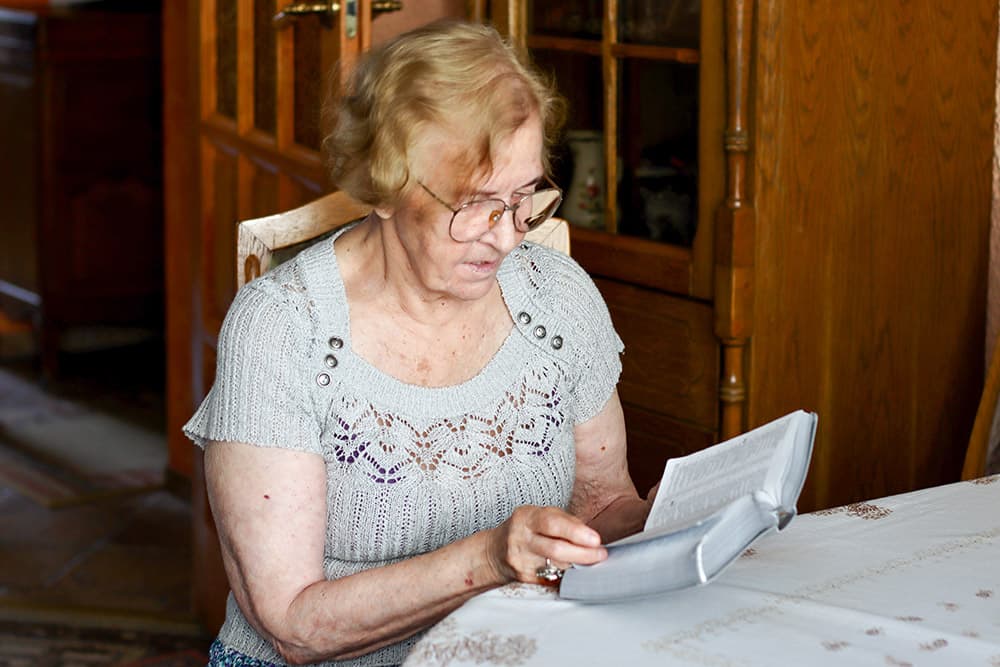 An elderly woman reading a book
