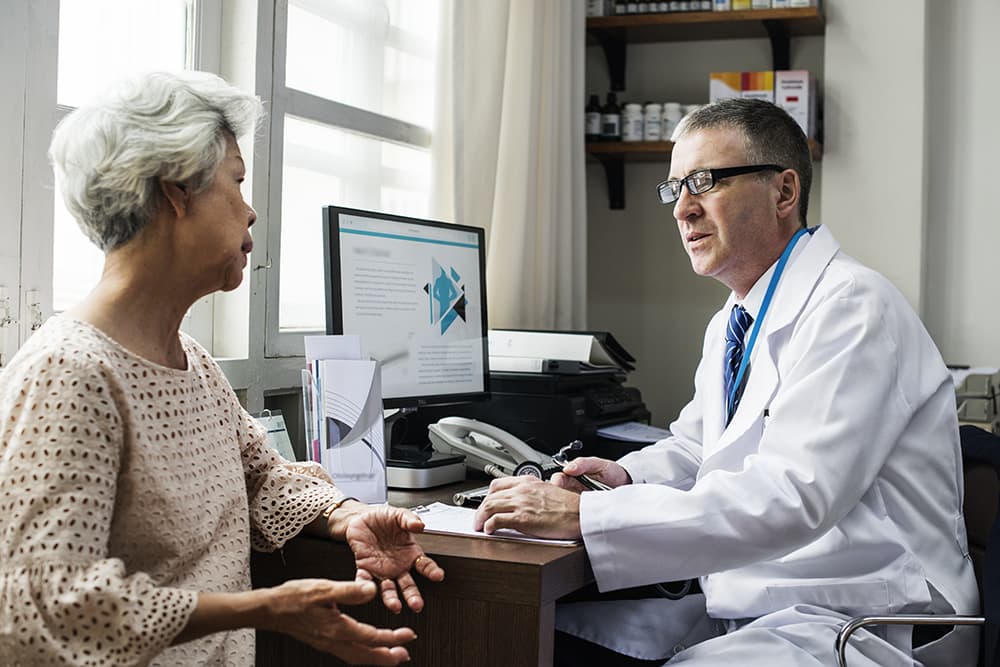 A doctor speaking with his female patient