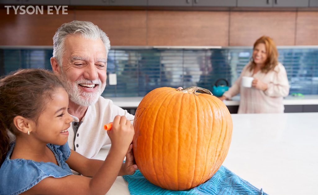Grandparents and grandchild carving a pumpkin, understanding eye safety tips for halloween