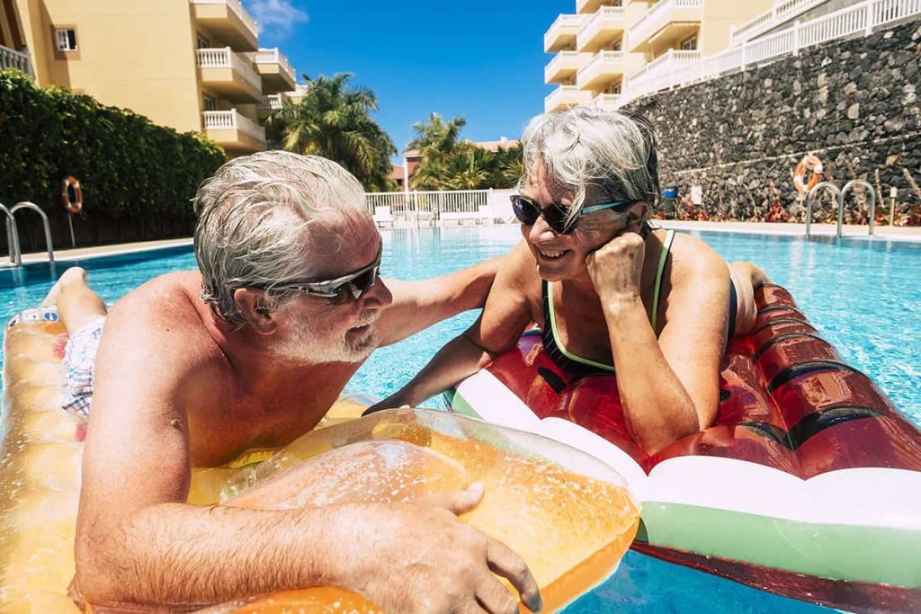 A senior couple enjoying summer floating in the pool