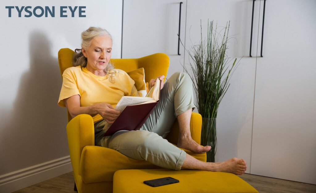 person reading a book in a chair reading all about the light adjustable lenses