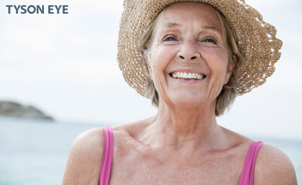 a person at a beach, smiling showcasing the best lenses for cataract surgery